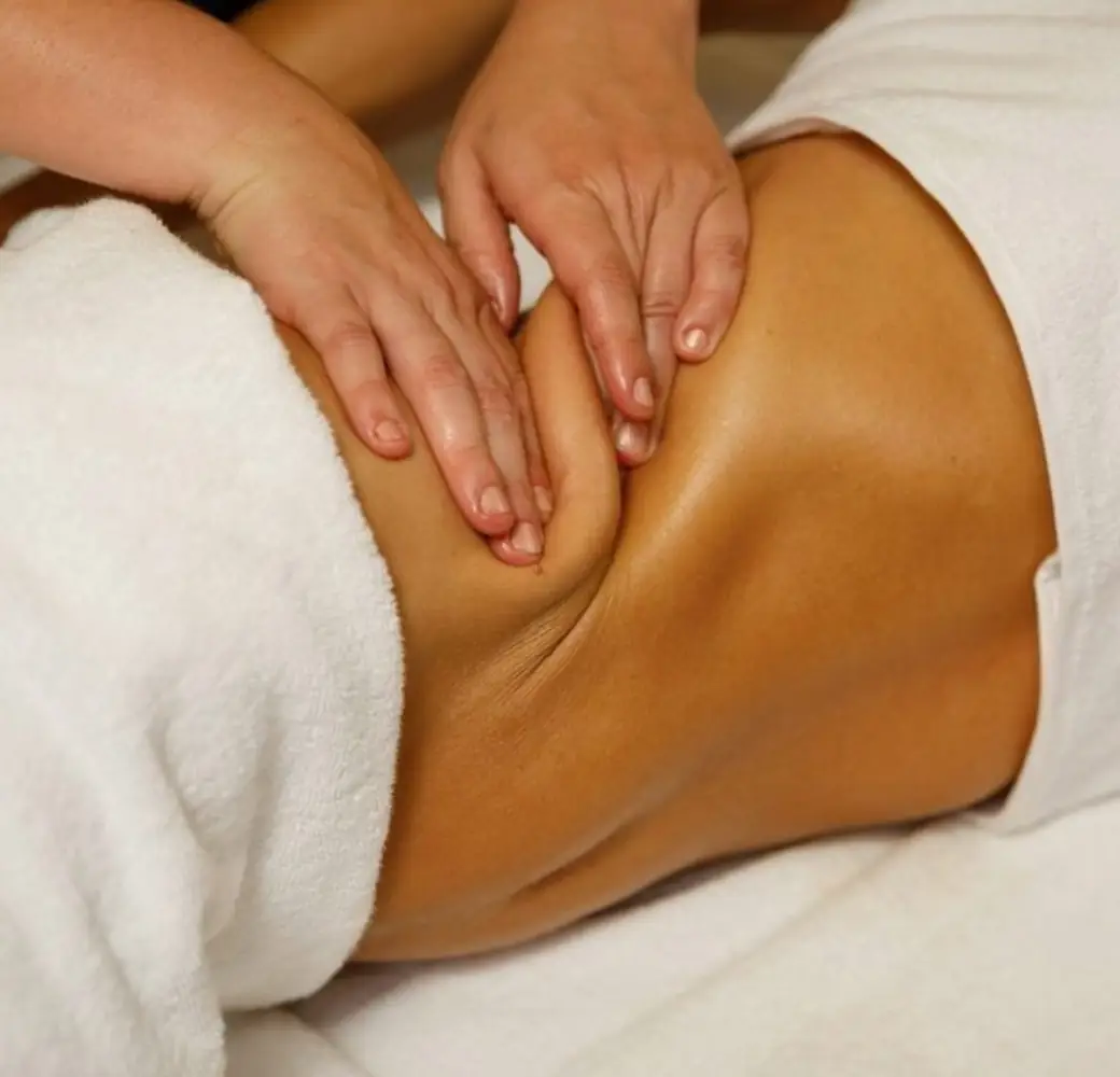Palper-rouler appuyé sur le ventre, technique anti-cellulite, serviette blanche.